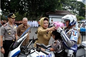 bupati uningan saat mengenakan helm kepada salah seorang anak tk.